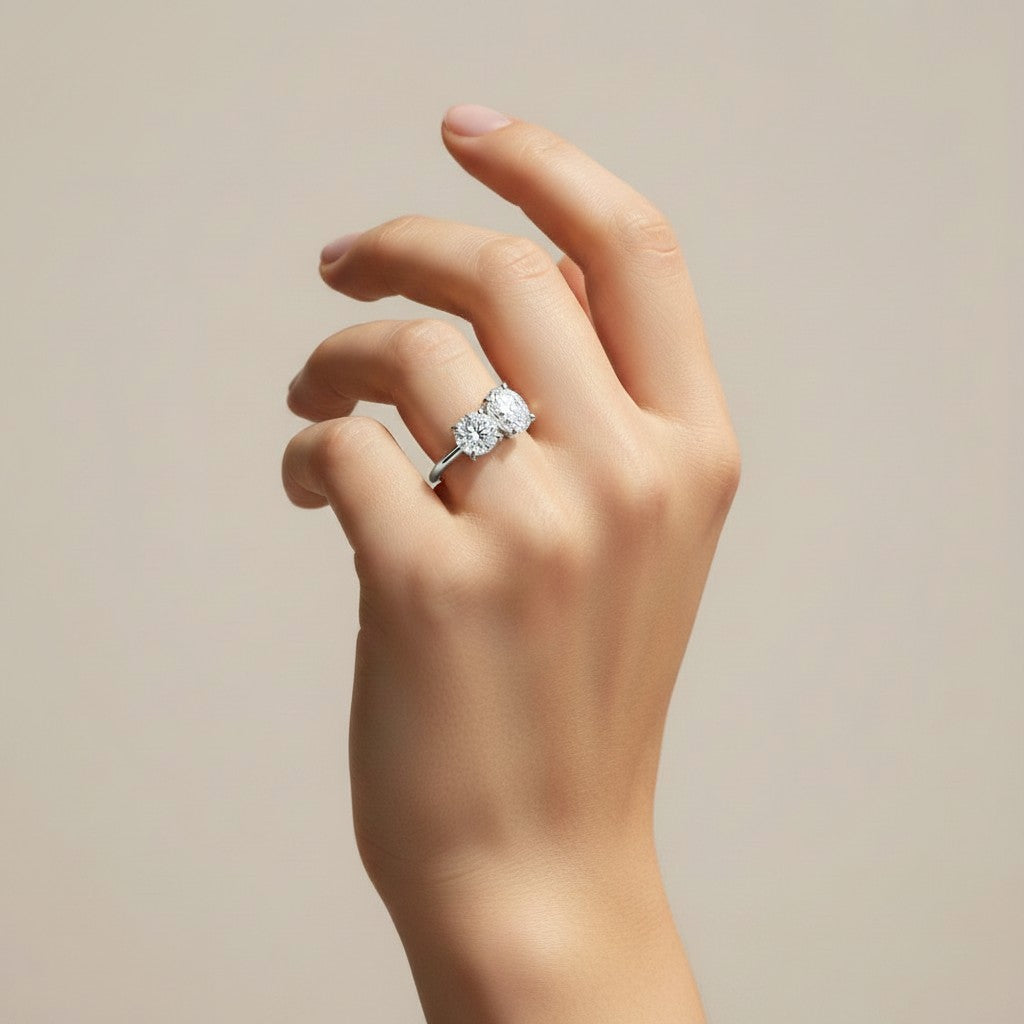 My Store 4 Toi et Moi engagement ring featuring a round and oval diamond on a polished gold band worn on a hand
