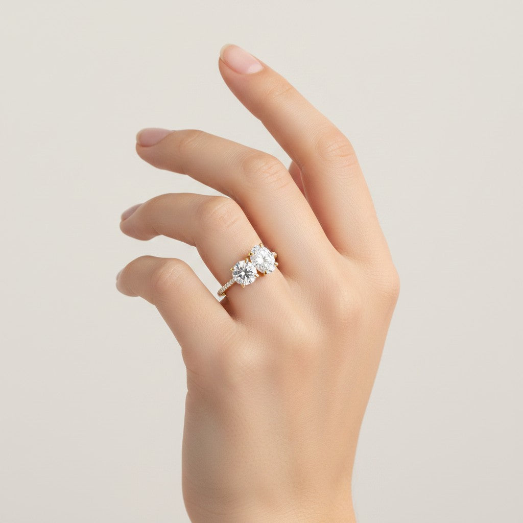 My Store 4 Toi et Moi engagement ring with round and oval diamonds on a pavé gold band worn on a woman's hand