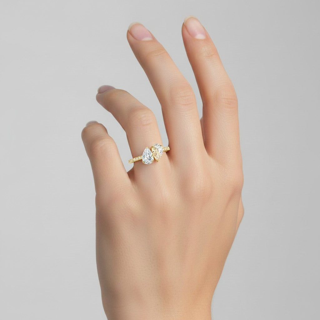 My Store 4 Toi et Moi engagement ring featuring two pear-cut diamonds on a pavé solid yellow gold band on a hand.
