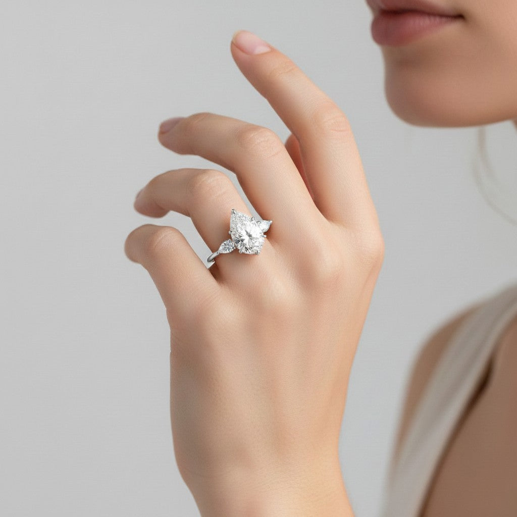 My Store 4 18K solid gold trilogy ring featuring a pear-cut lab-grown diamond flanked by two smaller side stones.