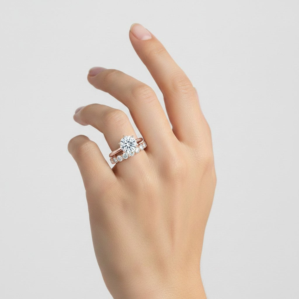 My Store 4 round tulip solitaire engagement ring and eternity band set in 18K yellow gold worn on a woman's hand.