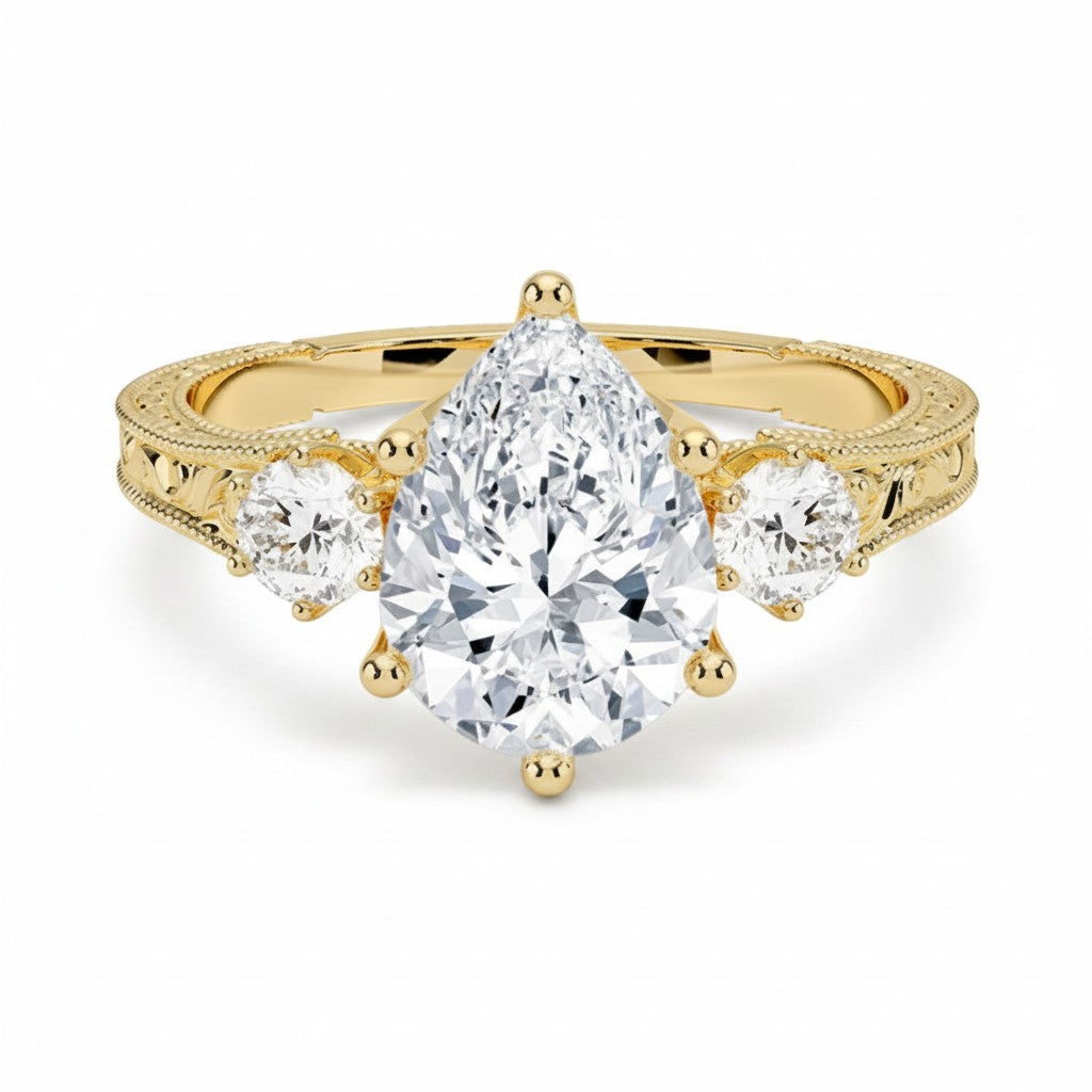 My Store 4 vintage pear cut three-stone engagement ring in 18K yellow gold with engraved scrollwork and milgrain detail.