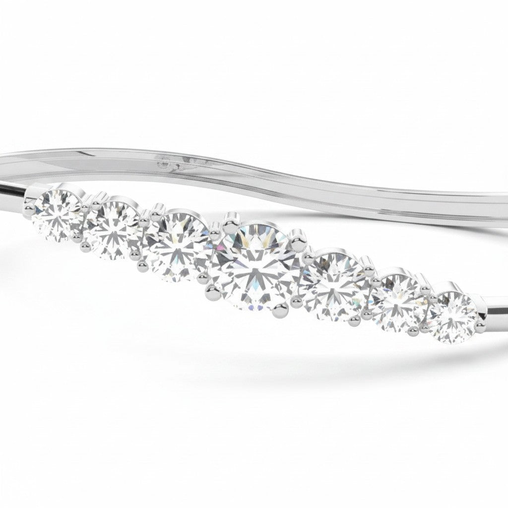 My Store 4 wave-contoured gold bangle featuring a graduated row of brilliant round diamonds in a shared-prong setting.
