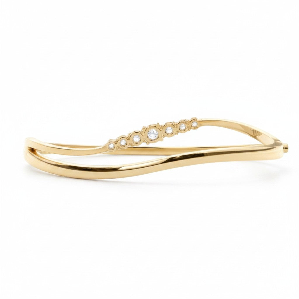My Store 4 wave-contoured yellow gold bangle bracelet featuring a graduated row of round brilliant diamonds.