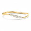 My Store 4 wave-contoured yellow gold bangle featuring a graduated row of brilliant round diamonds in shared prongs.