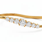 My Store 4 wave-contoured gold bangle featuring a graduated row of sparkling round brilliant diamonds in shared prongs.