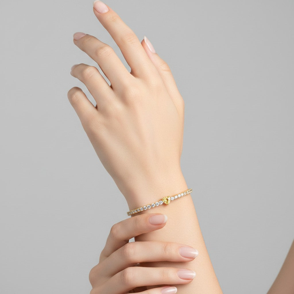 My Store 4 tennis bracelet with a central yellow heart-cut diamond and round white diamonds on a woman's wrist