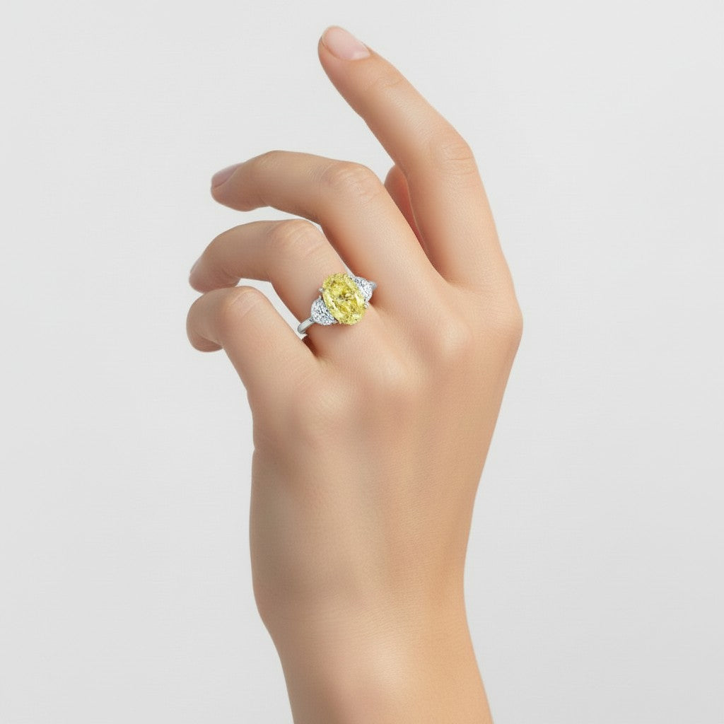 My Store 4 18K solid gold trilogy ring featuring a fancy yellow oval lab-grown diamond on a woman's hand.