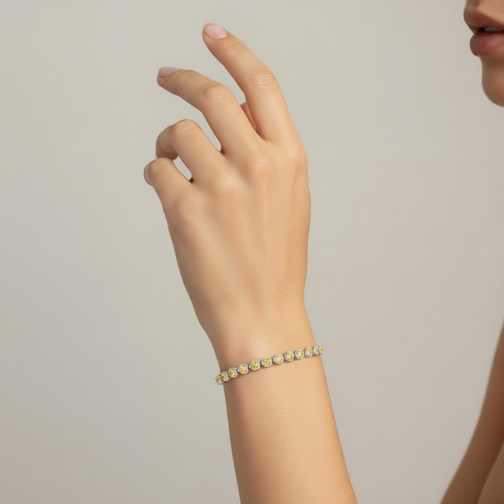 My Store 4 yellow gold tennis bracelet featuring pear-cut fancy yellow diamonds in half-bezel settings on a wrist.