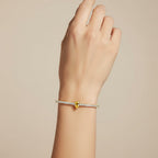 My Store 4 tennis bracelet featuring a central pear-cut fancy yellow diamond surrounded by round white diamonds in gold