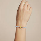 My Store 4 tennis bracelet featuring a central fancy yellow pear-cut diamond on a line of round white diamonds.