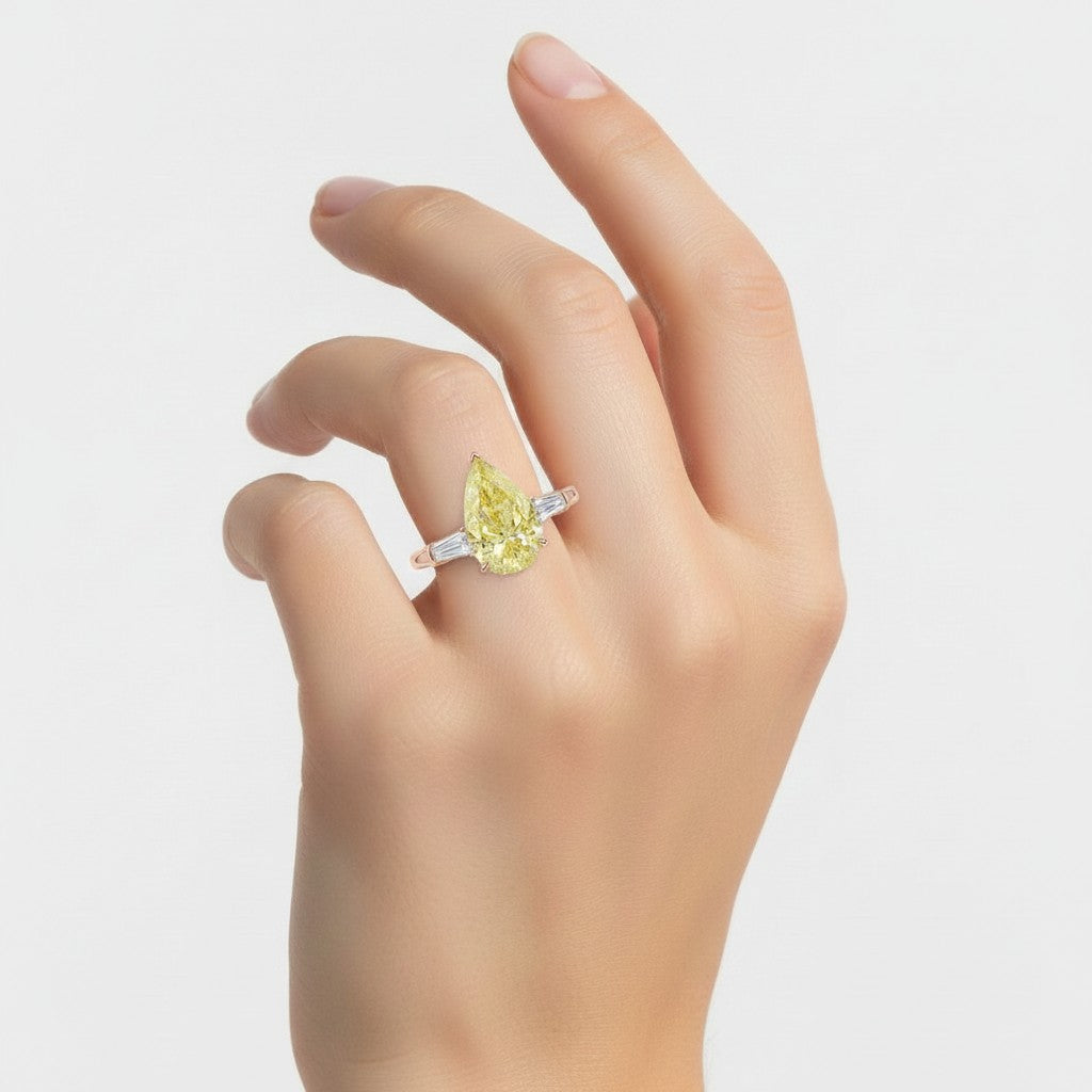 My Store 4 18K solid gold trilogy ring featuring a yellow pear-cut diamond and baguette side stones on a hand