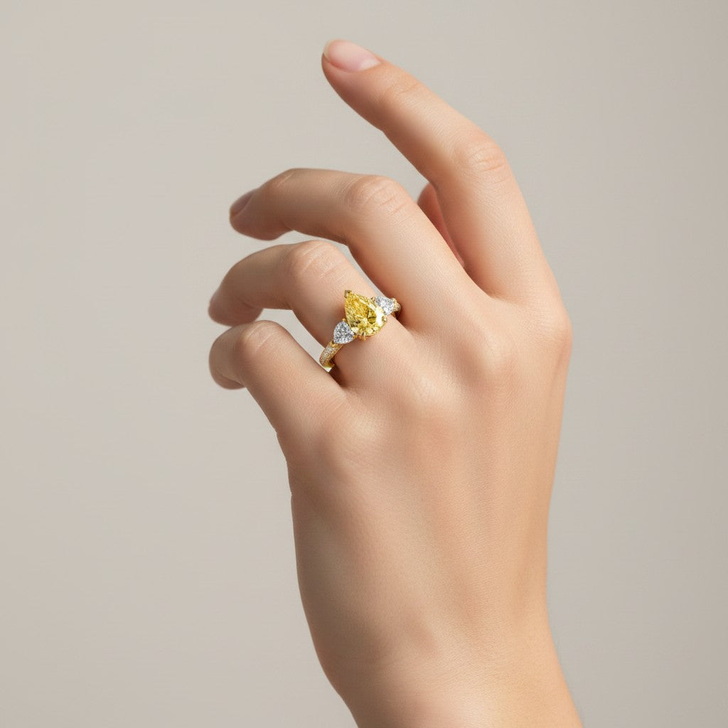 My Store 4 18K solid gold trilogy ring featuring a fancy yellow pear-cut lab diamond on a woman's hand