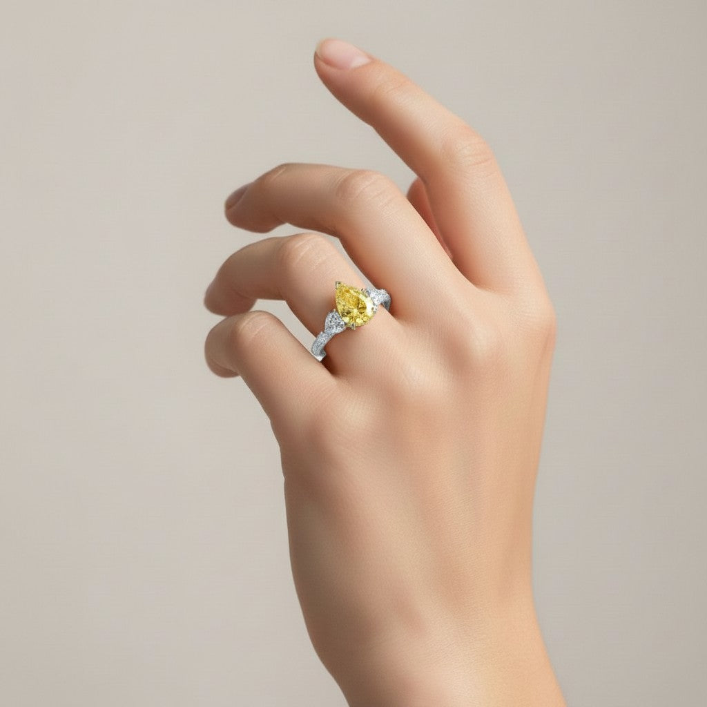 My Store 4 18K gold trilogy ring featuring a fancy yellow pear-cut lab diamond on a woman's hand