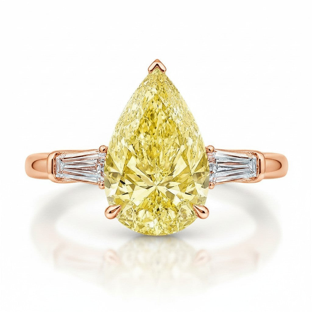 My Store 4 18K solid gold trilogy ring featuring a fancy yellow pear-cut diamond flanked by baguette side diamonds.
