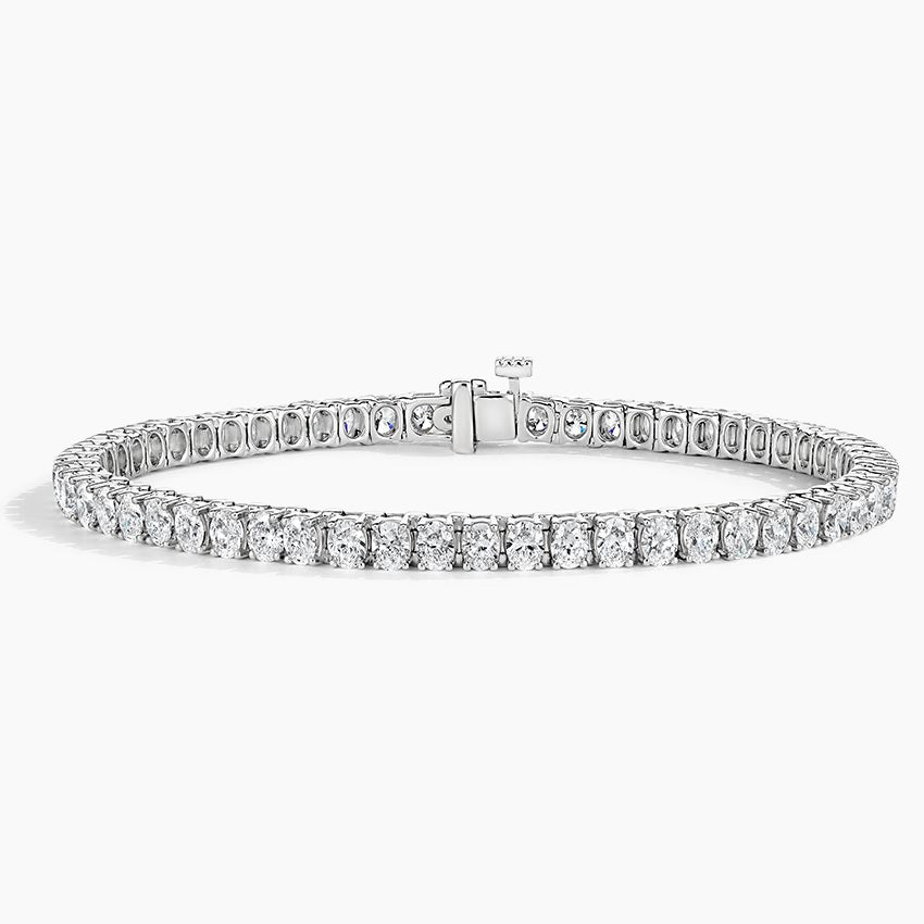 Oval cut diamond tennis bracelet in white gold with secure clasp on white background
