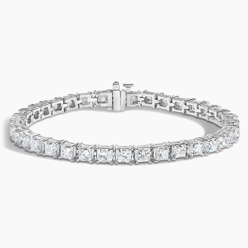 Princess cut diamond tennis bracelet in white gold set against a white background