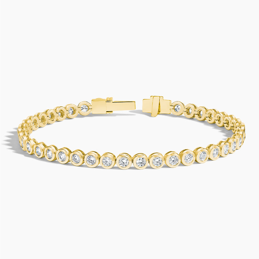 Yellow gold tennis bracelet with round lab-grown diamonds, bezel set, on white background